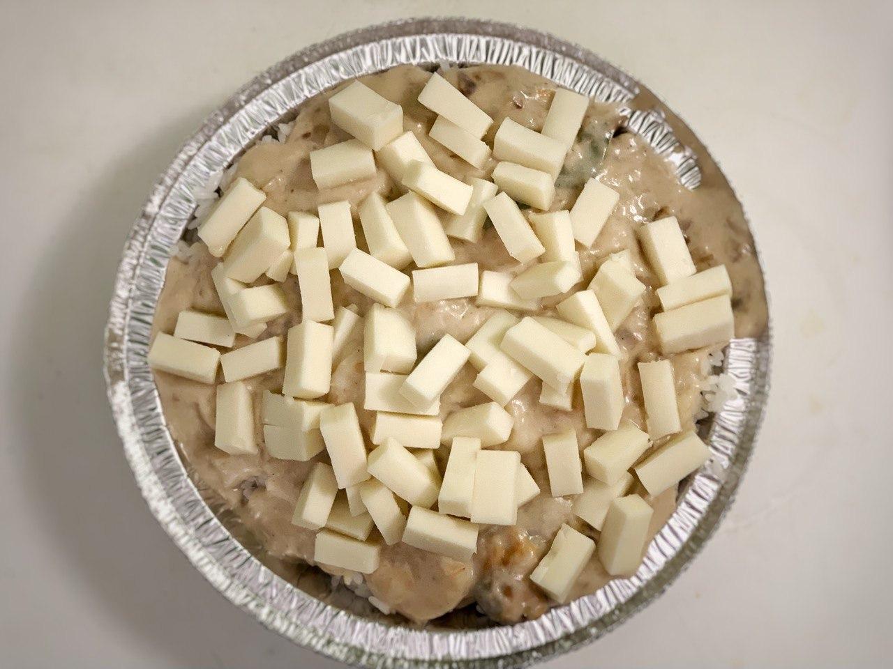 In the circle aluminum tray or any oven safe container, place cooked <b>rice</b>, 1 cup of <b>cream sauce</b>, and a handful of <b>cheese</b>.